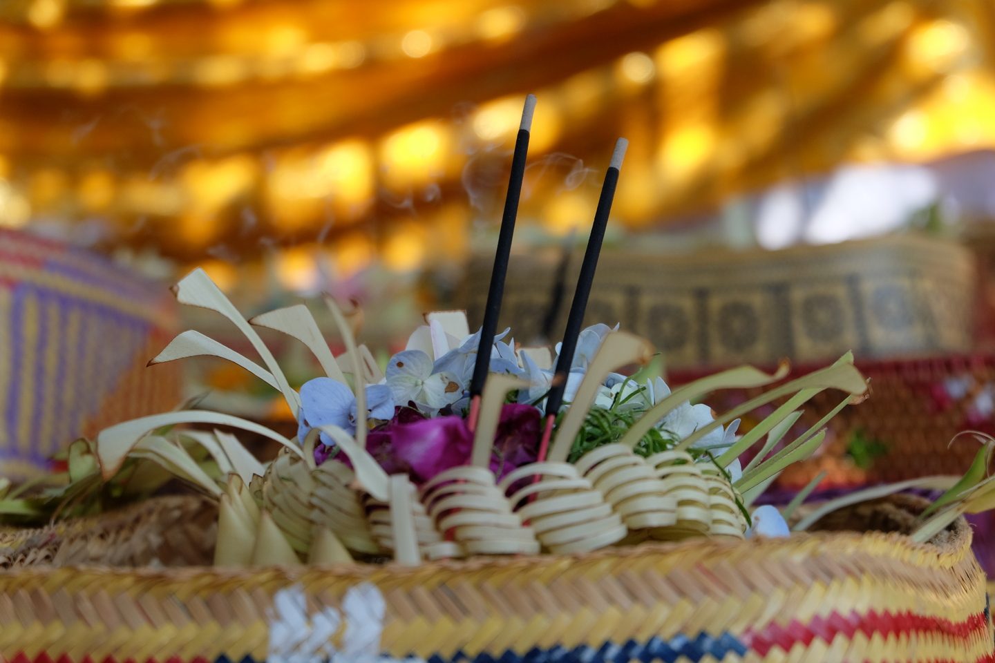How to take care of a mala 13 Mebanten in Bali: a woven basket with flowers and burning incense
